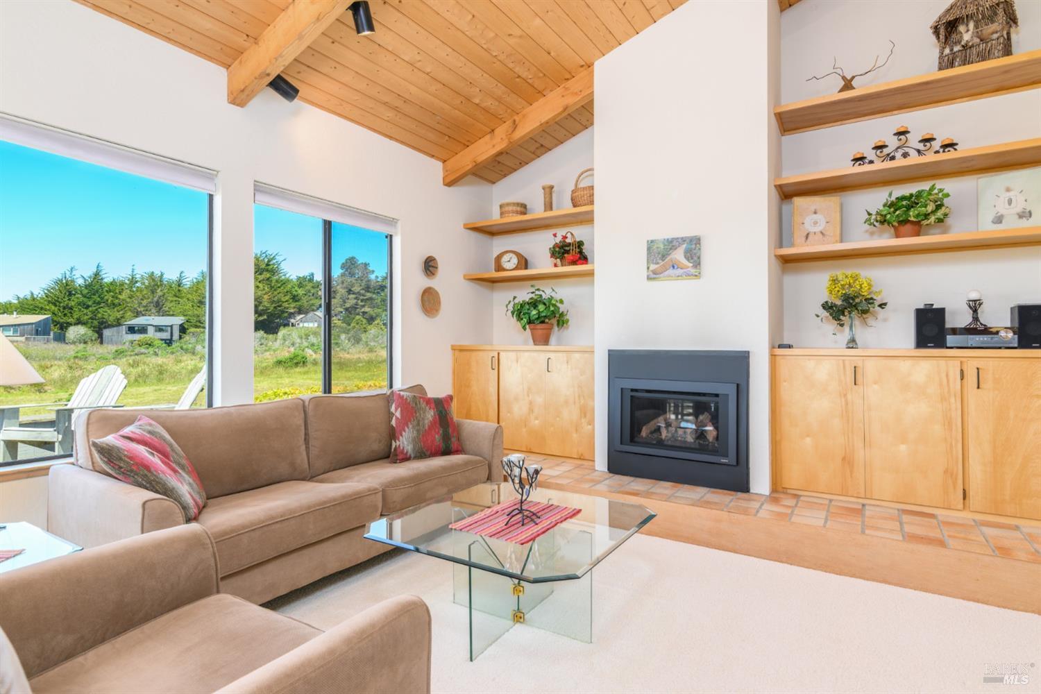 267 Sea Stack The Sea Ranch, CA 95497 - Photo 17 of 35 a living room with furniture a fireplace and a floor to ceiling window