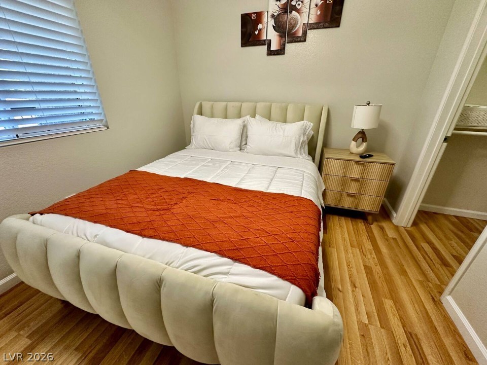 9580 West Reno Avenue, Unit 169 Las Vegas, NV 89148 - Photo 8 of 15 Hardwood-style flooring and a window with blinds define this inviting sleeping space.