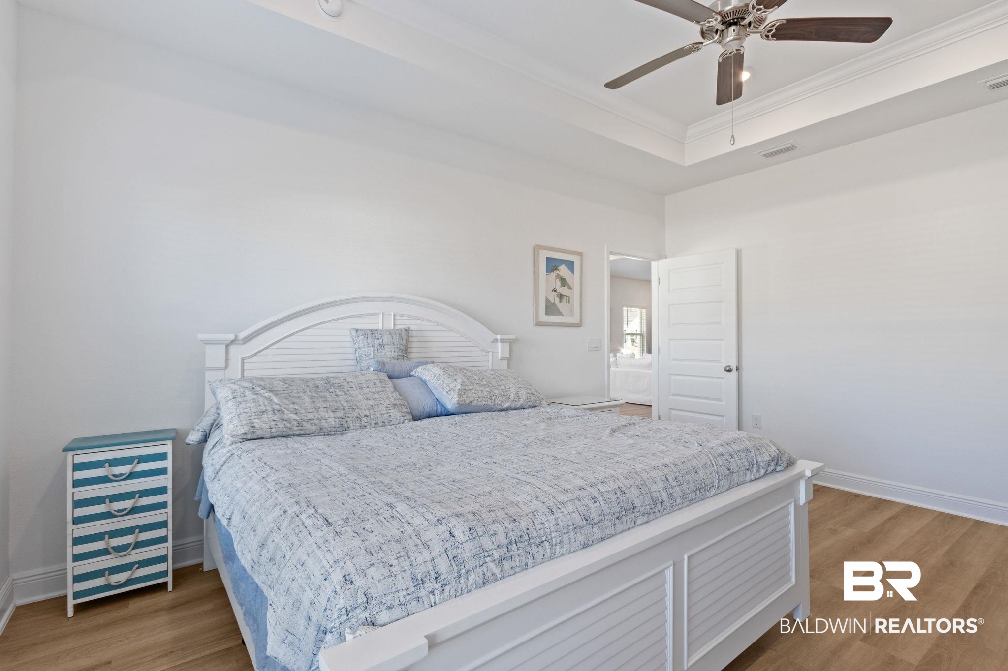 12919 Torrent Road Fairhope, AL 36532 - Photo 31 of 74 Bedroom featuring crown molding, light wood-style flooring, a raised ceiling, and ceiling fan