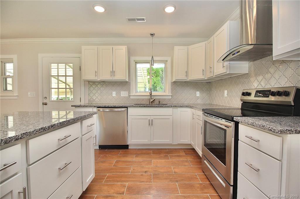 6201 Tuckaseegee Road Charlotte, NC 28208 - Photo 7 of 21 a kitchen with granite countertop white cabinets stainless steel appliances a sink and a window