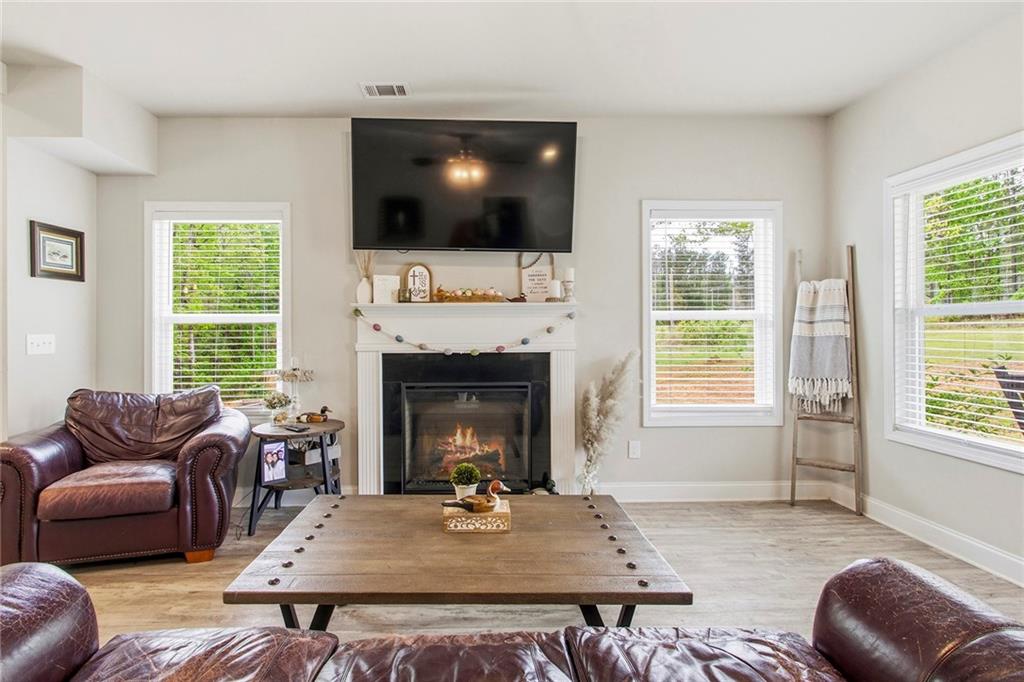 171 Strickland Loop Forsyth, GA 31029 - Photo 8 of 25 a living room with furniture a flat screen tv and a fireplace