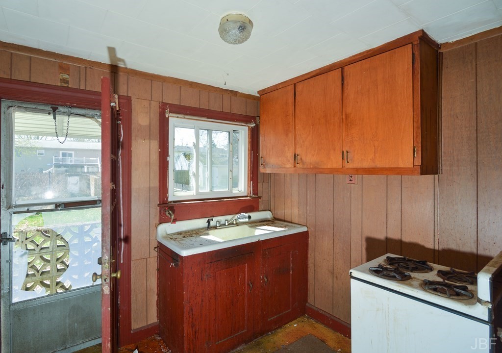 495 Chicago Street Fall River, MA 02721 - Photo 15 of 26 a kitchen that has a stove and a wooden cabinets