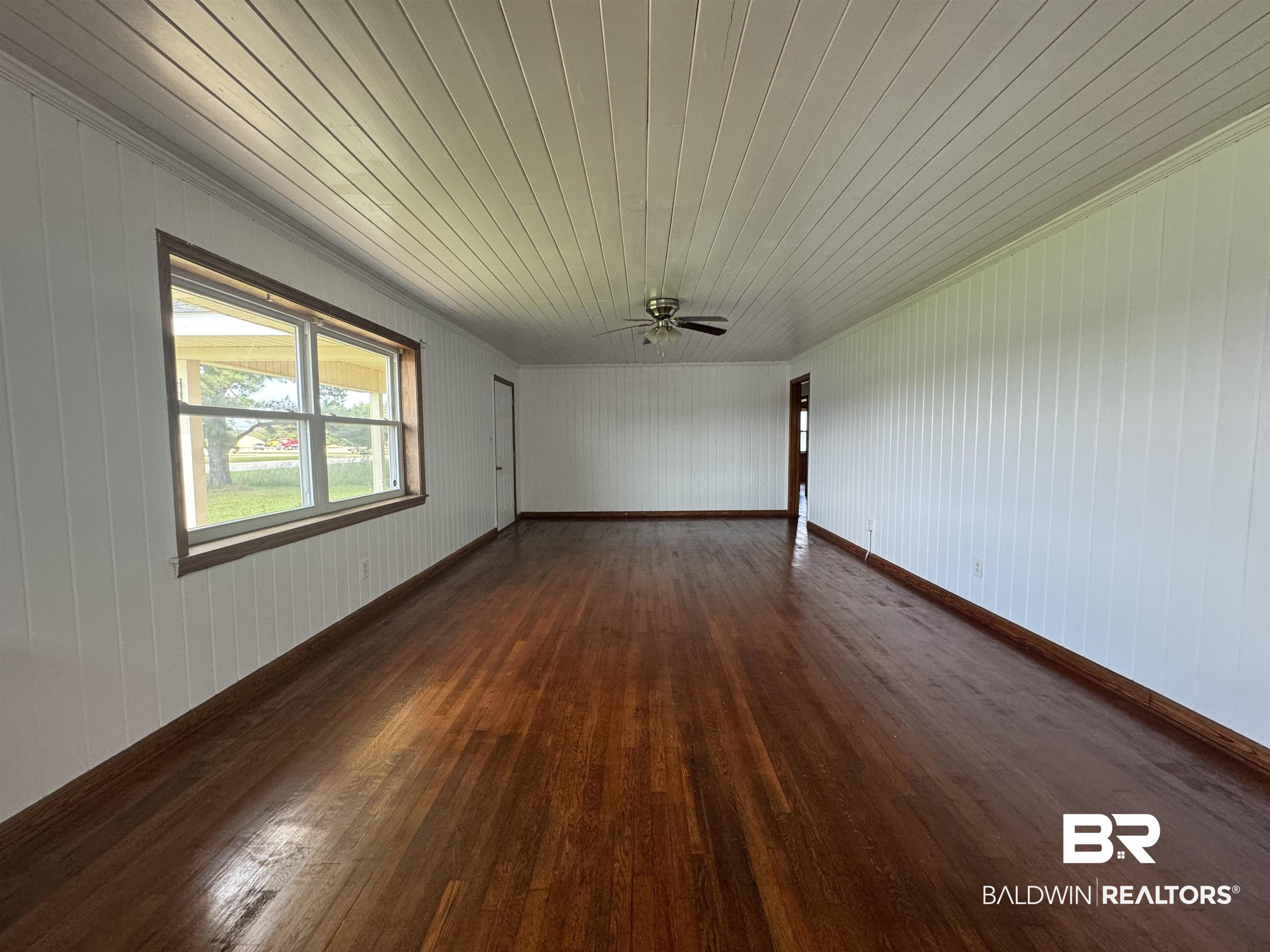 22720 Highway 31 Flomaton, AL 36441 - Photo 9 of 22 Unfurnished room with wood walls, ceiling fan, dark hardwood / wood-style floors, and wooden ceiling