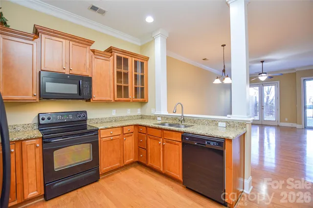 a kitchen with stainless steel appliances granite countertop a stove a sink and a microwave