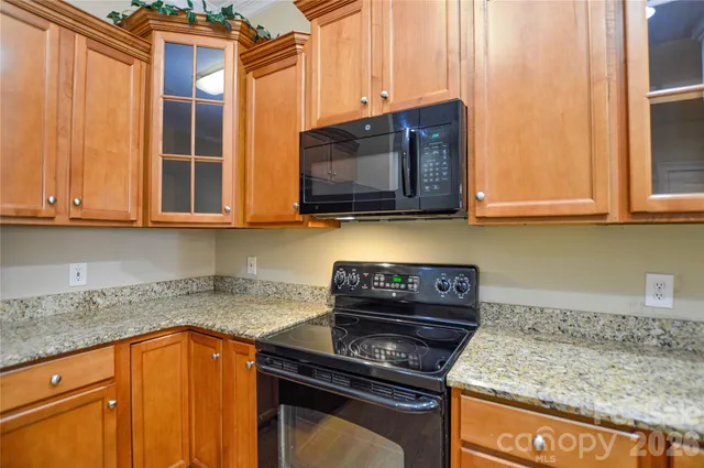 a kitchen with stainless steel appliances granite countertop a stove a microwave and cabinets