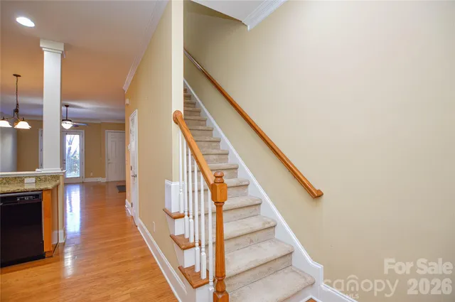 a view of a hallway with wooden floor and staircase