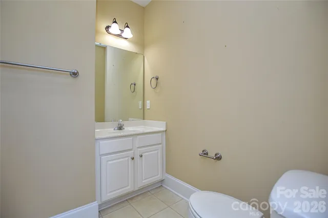a bathroom with a granite countertop sink a toilet and mirror