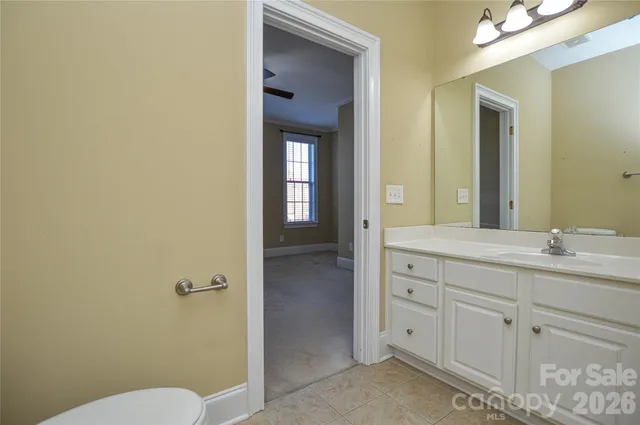 a bathroom with a granite countertop sink mirror and toilet