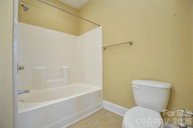 a white toilet sitting next to a bath tub
