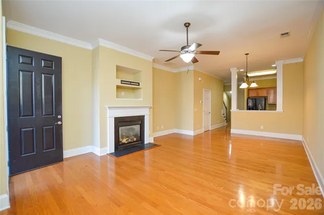 a view of a livingroom with a fireplace a chandelier and wooden floor