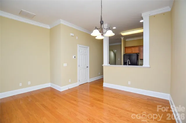 a view of a room with a large window and chandelier fan