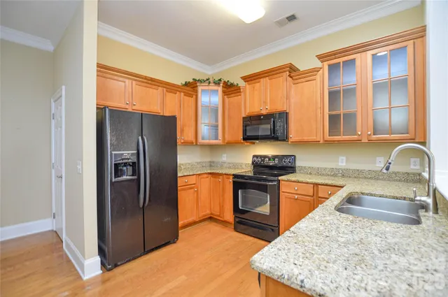 a kitchen with stainless steel appliances granite countertop a refrigerator stove top oven and sink