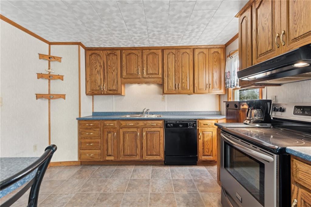 124 Hampton Road Mill Run, PA 15464 - Photo 9 of 32 a kitchen with stainless steel appliances granite countertop a stove a sink and a refrigerator