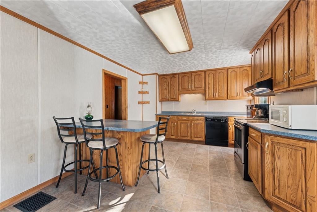 124 Hampton Road Mill Run, PA 15464 - Photo 10 of 32 a kitchen with appliances cabinets and chair