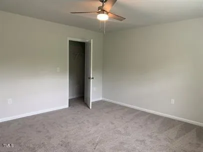 an empty room with a ceiling fan and a window