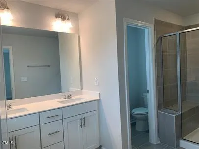 a bathroom with a double vanity sink a toilet and a mirror
