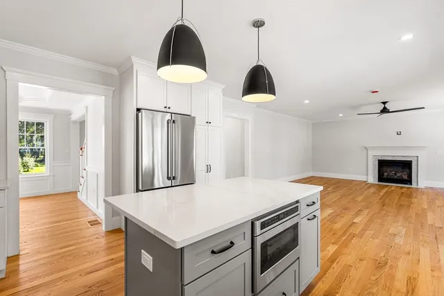 a kitchen with a stove a sink a microwave and wooden floor