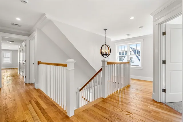a view of a hallway with wooden floor and stairs