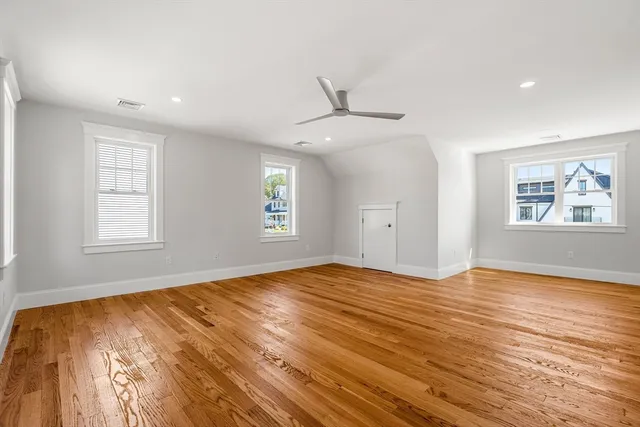 a view of an empty room with window and wooden floor