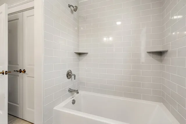 a white bath tub sitting next to a white wall