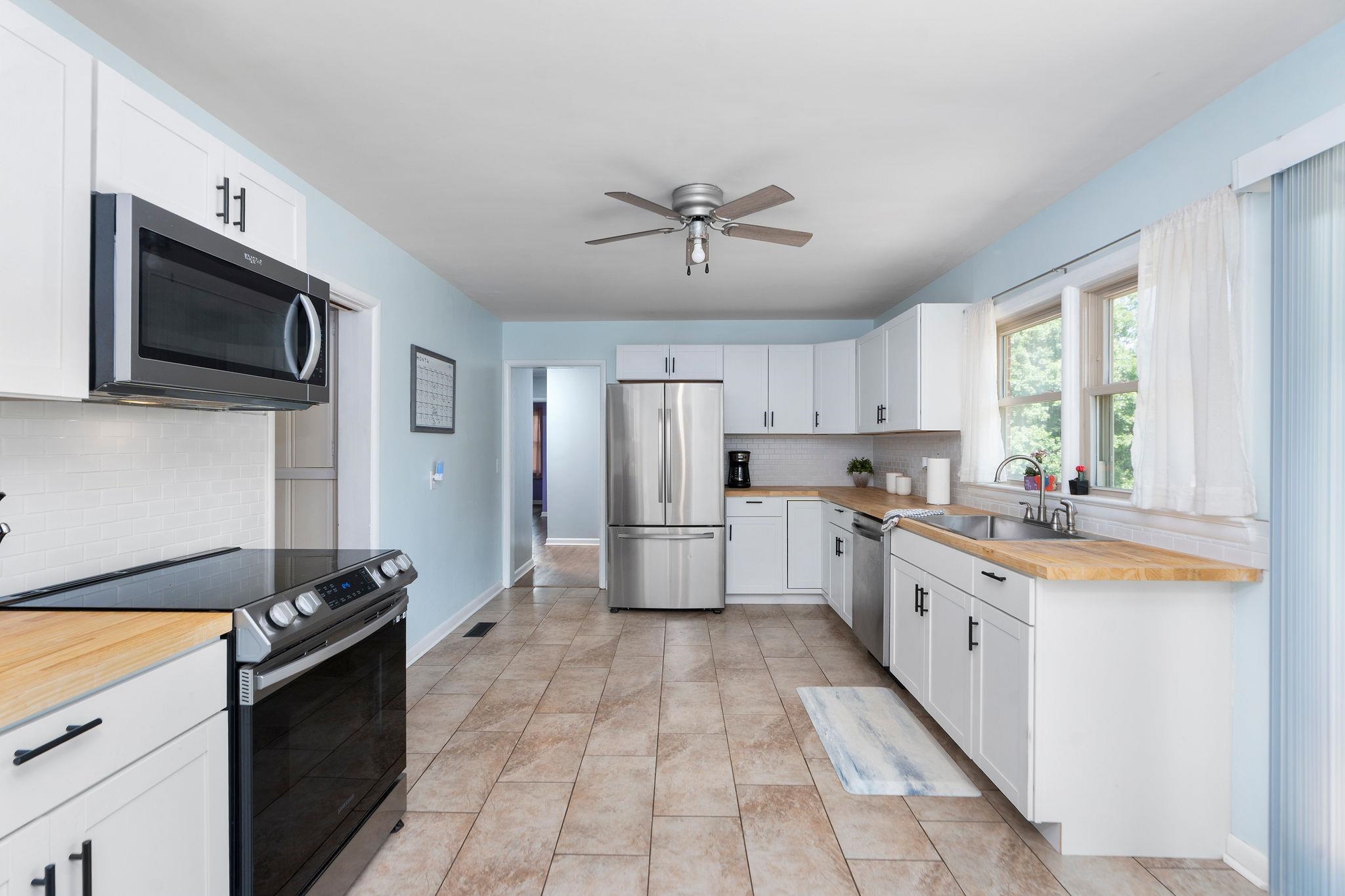 1064 Ladd Road Waynesboro, VA 22980 - Photo 12 of 51 a large kitchen with stainless steel appliances kitchen island granite countertop a stove sink and cabinets