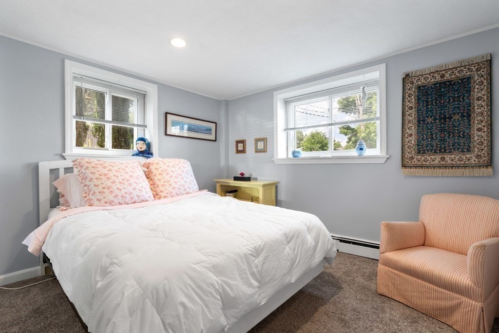 64 Bryon Road, Unit B641 Boston, MA 02467 - Photo 11 of 26 a bedroom with a large bed couch and two windows