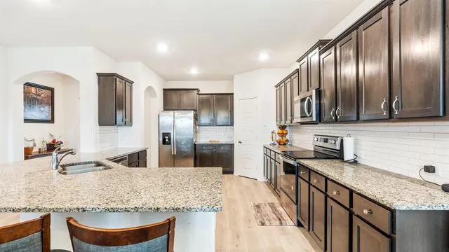 a kitchen with stainless steel appliances granite countertop a sink stove and refrigerator