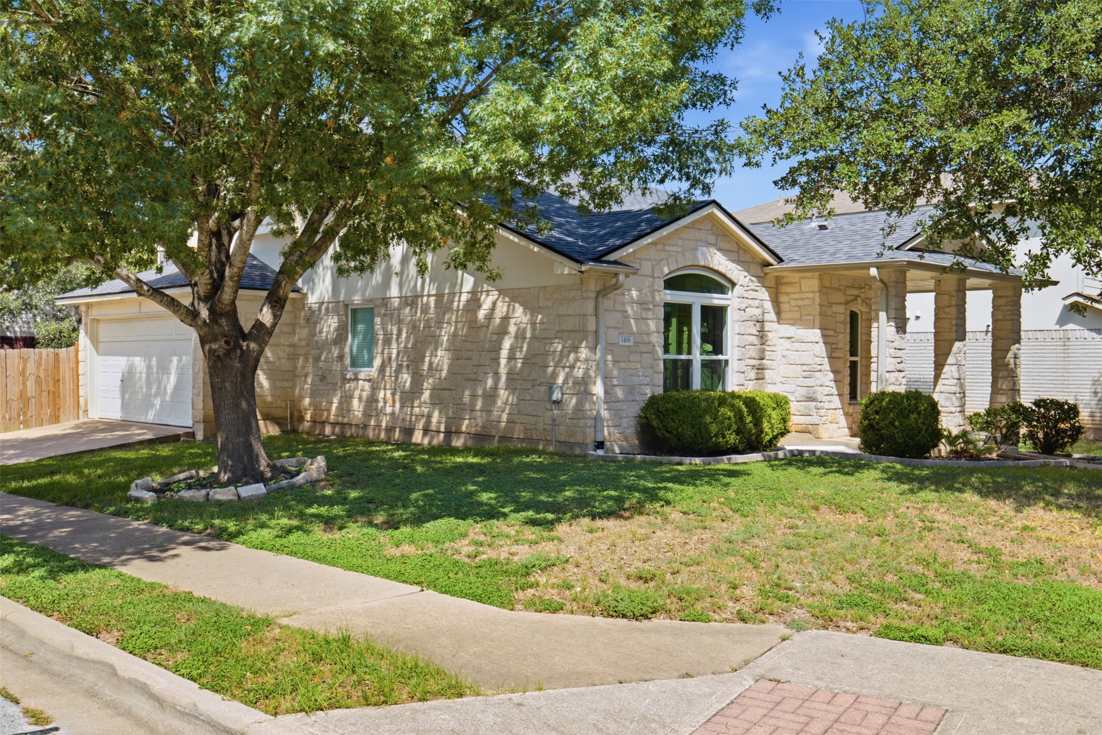 1416 Roxanne's Run Pflugerville, TX 78660 - Photo 3 of 35 A classic stone facade with an arched window and covered entryway creates inviting curb appeal.