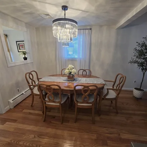 a view of a dining room with furniture wooden floor and chandelier