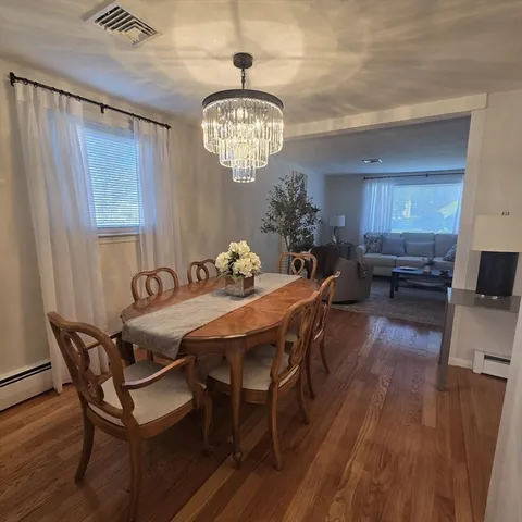 a view of a dining room with furniture wooden floor and a chandelier