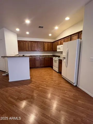 a kitchen with stainless steel appliances granite countertop a refrigerator a sink and a stove