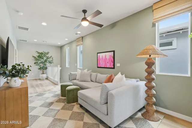 a living room with furniture a chandelier and a potted plant