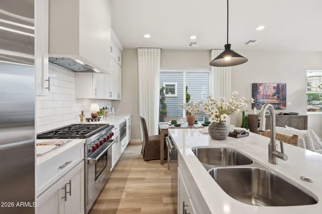 a kitchen with stainless steel appliances a sink a stove and a wooden floors