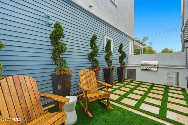 a view of a patio with table and chairs with wooden floor and fence