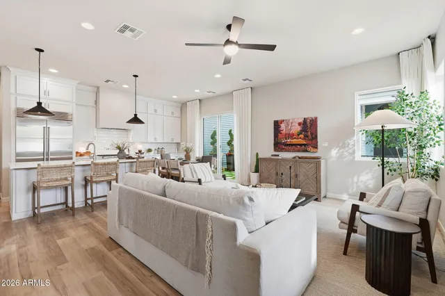 a living room with furniture kitchen view and a chandelier