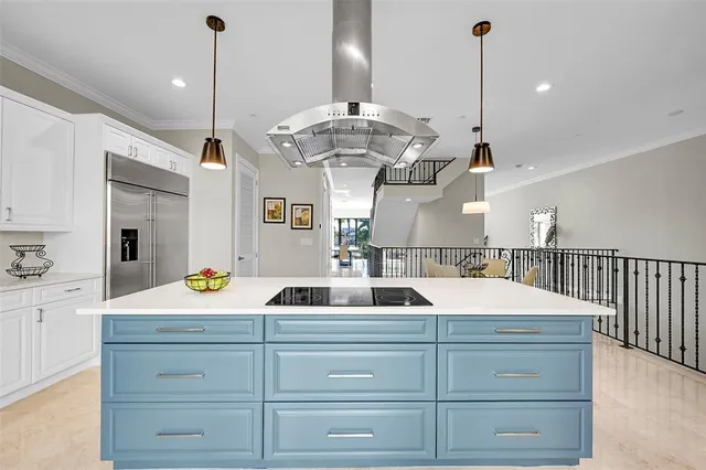 a kitchen with stainless steel appliances kitchen island granite countertop a table chairs and a stove