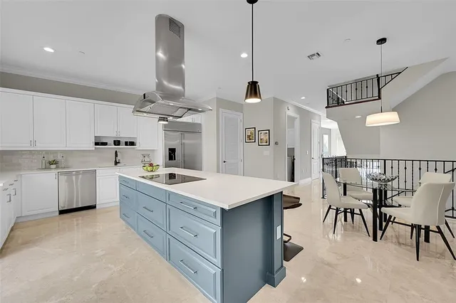 a kitchen with kitchen island granite countertop a sink counter top space appliances and cabinets