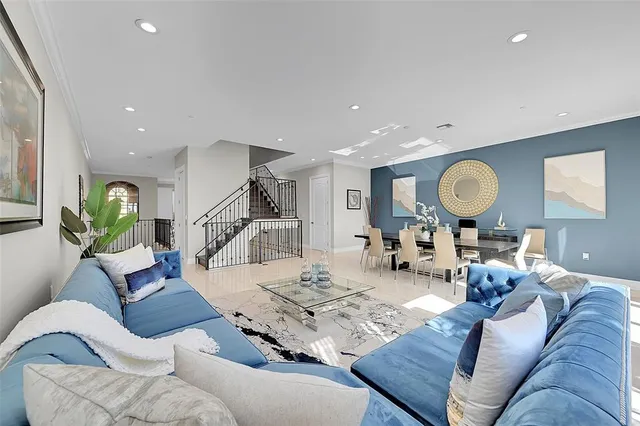 a living room with lots of furniture and view of kitchen