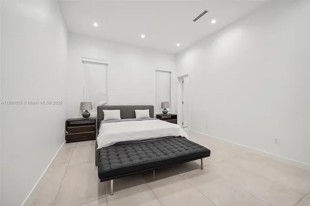 a bedroom with a bed and a flat tv screen on the dresser