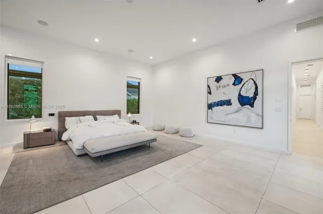 a spacious bedroom with a large bed and a view of living room