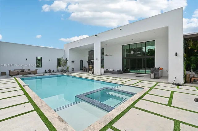 an aerial view of residential house with outdoor space and trees all around