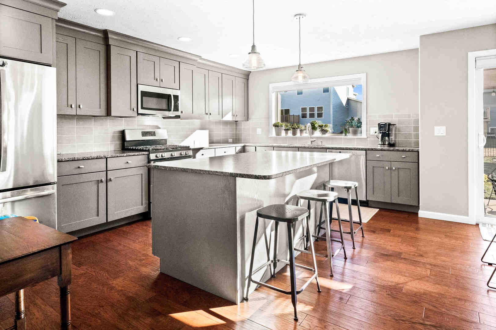 3615 Silverado Trail Normal, IL 61761 - Photo 11 of 37 a kitchen with stainless steel appliances granite countertop a stove top oven a refrigerator a sink and a dining table with wooden floor