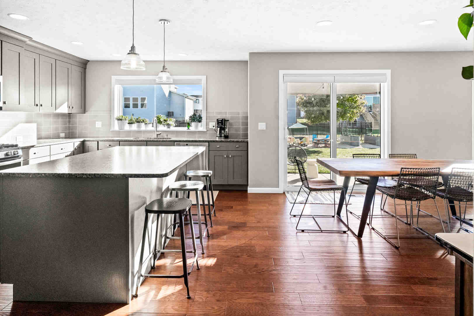 3615 Silverado Trail Normal, IL 61761 - Photo 15 of 37 a kitchen with stainless steel appliances granite countertop a stove top oven a sink a dining table and chairs with wooden floor