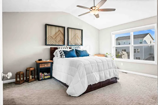 a bedroom with a bed a table and a large window