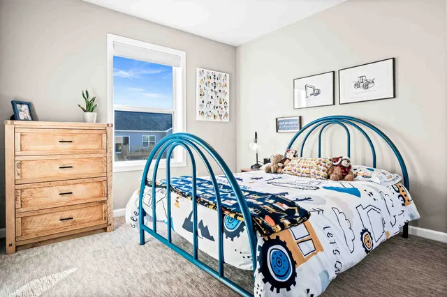 a view of a bedroom with furniture and mirror