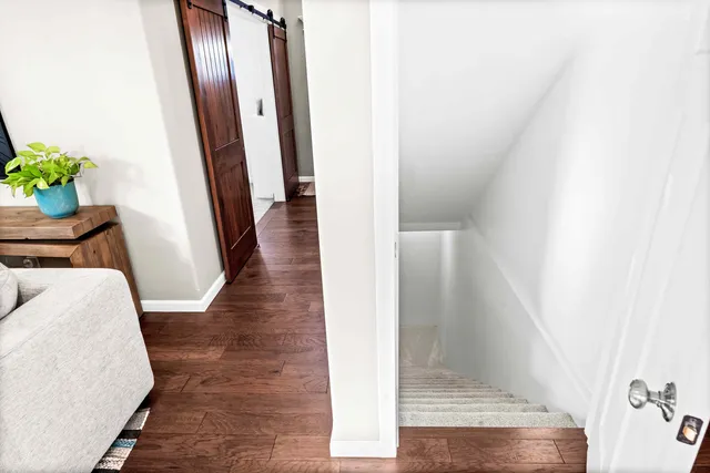 a view of a hallway with wooden floor and staircase