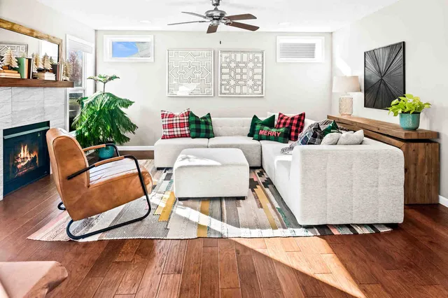 a living room with furniture floor to ceiling window and wooden floor