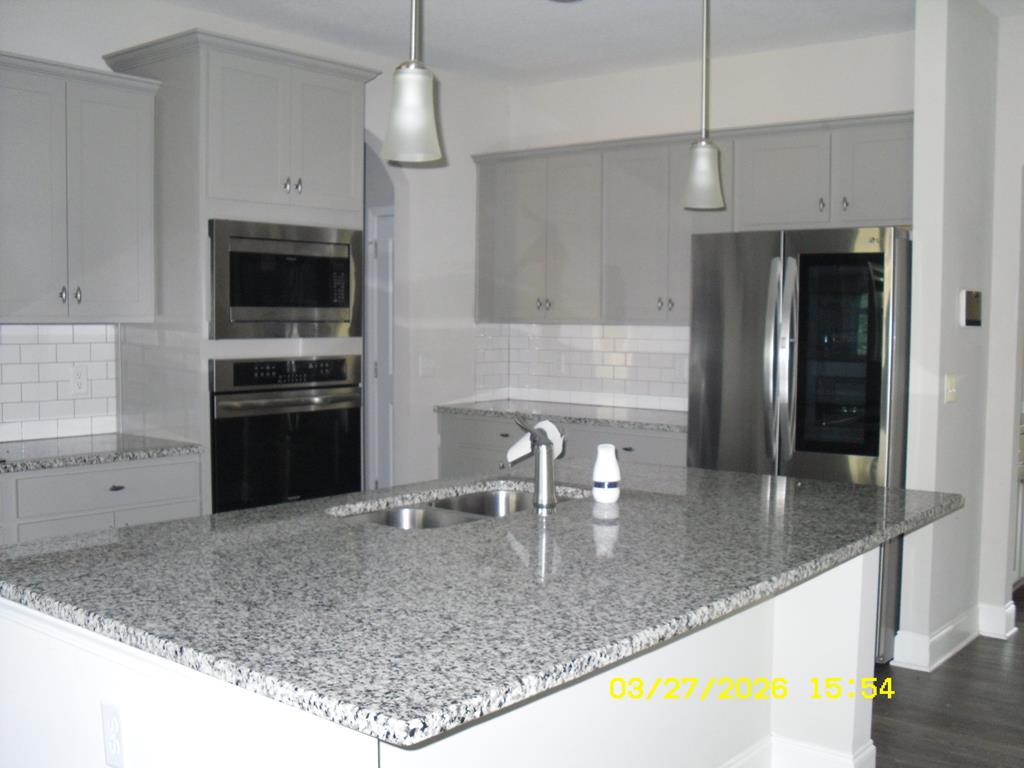 1325 Hawkins Road Woodland, GA 31836 - Photo 8 of 22 a kitchen with stainless steel appliances granite countertop a sink refrigerator and microwave