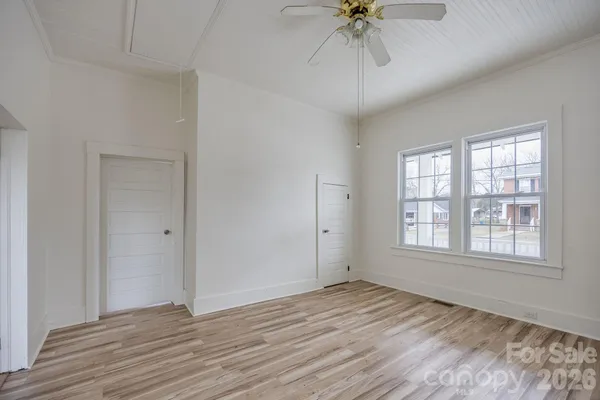 a bedroom with a bed a window and a flat screen television