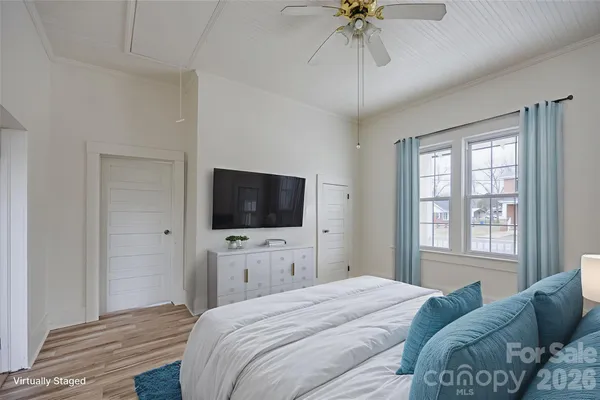 a view of an empty room with a window and wooden floor